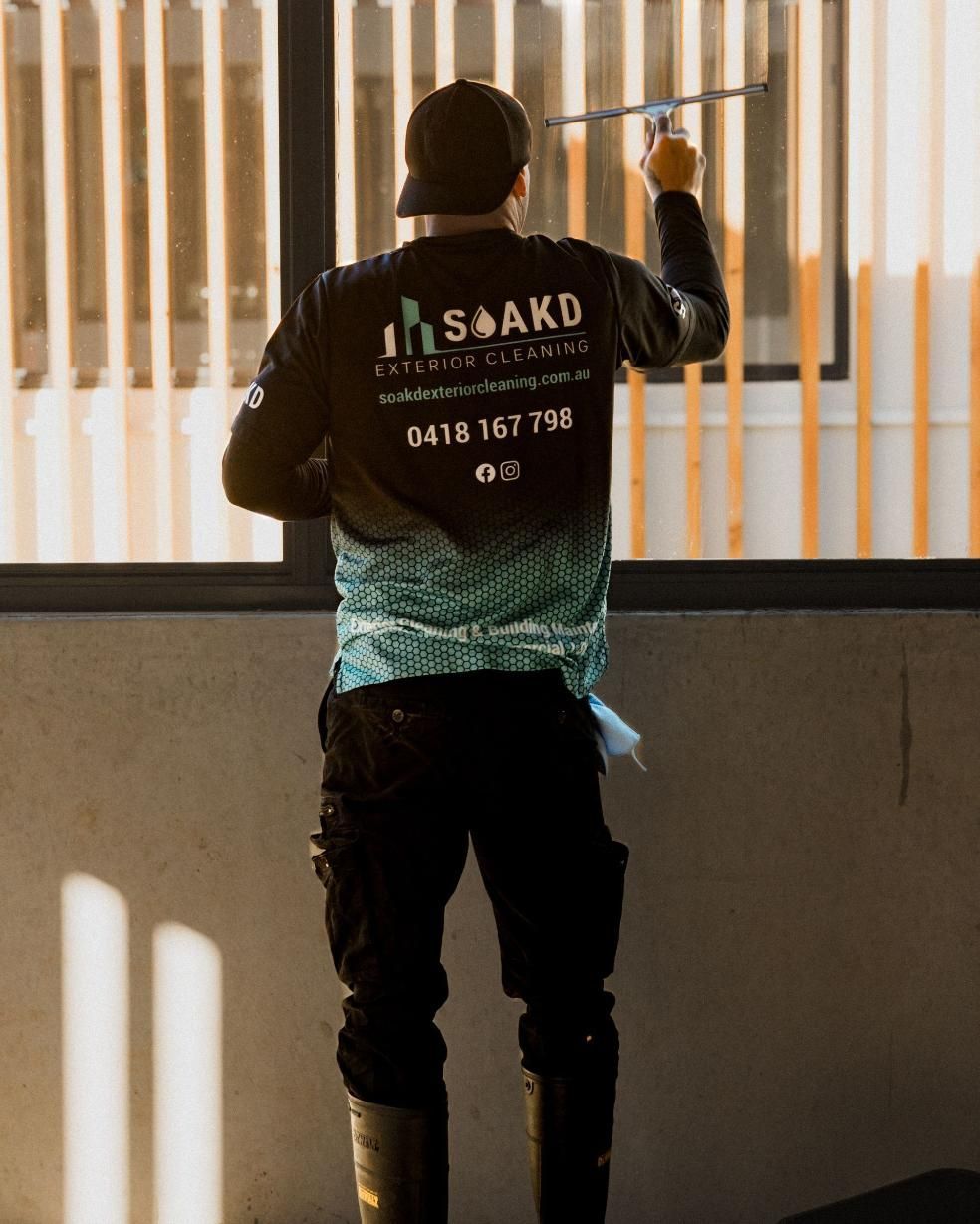 SOAKD operator cleaning windows with a water-fed pole system
