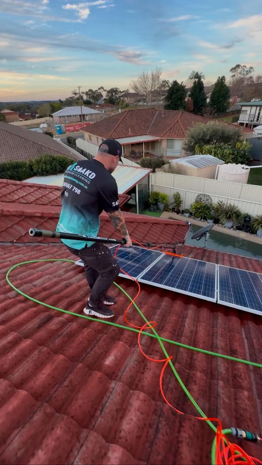 SOAKD technician cleaning rooftop solar panels with purified water
